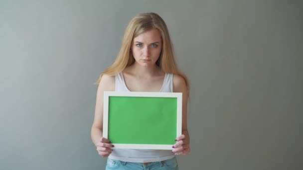 Atraktivní žena ukazuje greenkey copyspace s sledování bodů. — Stock video