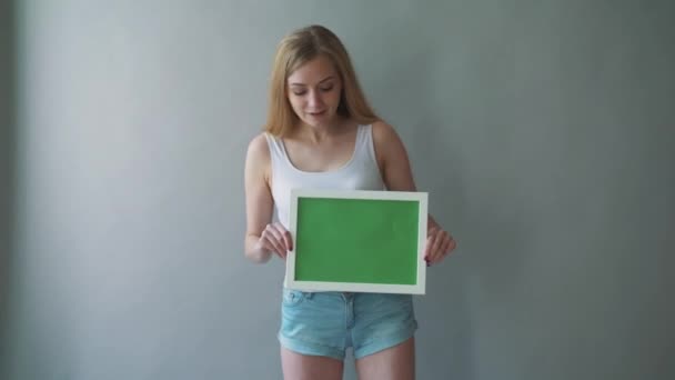 Atraktivní žena ukazuje greenkey copyspace s sledování bodů. — Stock video