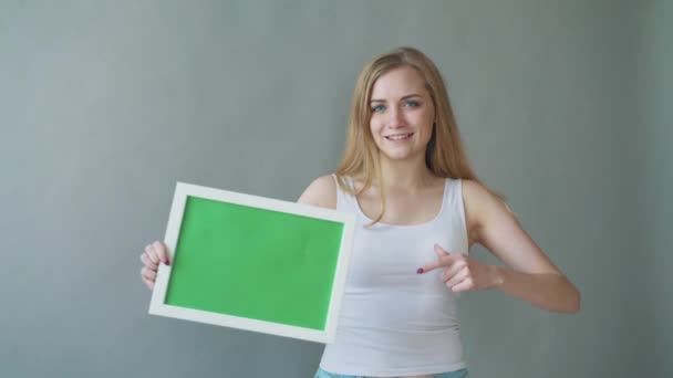 Mulher atraente mostra espaço verde copyspace com pontos de rastreamento . — Vídeo de Stock