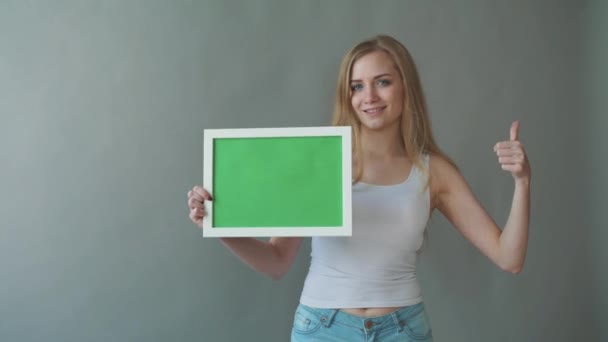 Привлекательная женщина показывает зеленое копировальное пространство с точками слежения . — стоковое видео