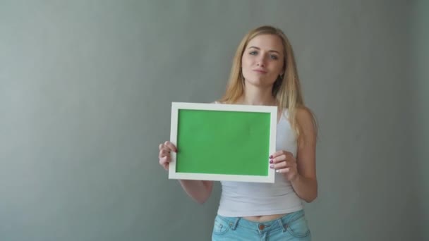 Mujer atractiva muestra copyspace Greenkey con puntos de seguimiento . — Vídeos de Stock