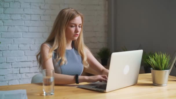 Бізнес-леді п'є воду за своїм столом у своєму офісі — стокове відео