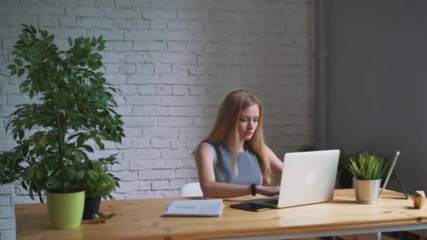 Женщина закрывает ноутбук и заканчивает рабочий день — стоковое видео