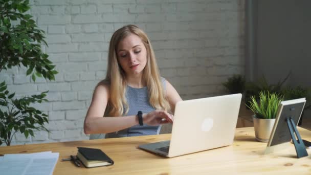 Портрет креативной женщины, сидящей за столом. Используя ноутбук. Она сидит в светлом и современном офисе — стоковое видео