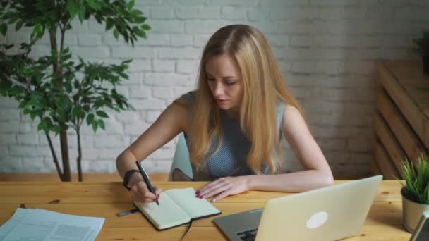 Mujer de negocios en el trabajo escribiendo en un cuaderno . — Vídeos de Stock