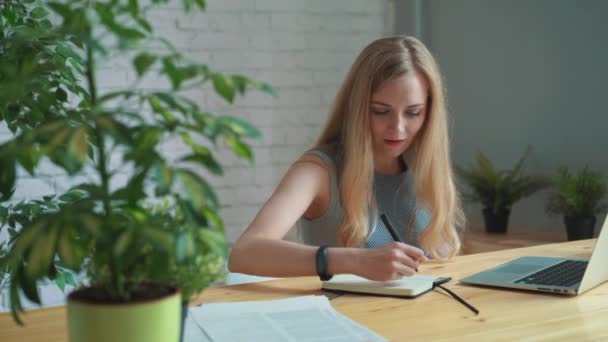 Zakenvrouw op het werk in een notitieboekje schrijven. — Stockvideo