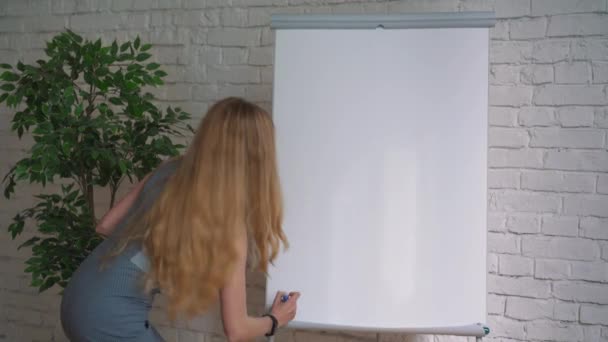 Επιχειρηματίας βάζοντας τις ιδέες του σε λευκό πίνακα κατά τη διάρκεια μιας παρουσίασης στην αίθουσα συνεδριάσεων. Εστίαση στα χέρια με μαρκαδόρο στυλό γράφοντας σε flipchart. Κοντινό πλάνο του χεριού με μαρκαδόρο και λευκό πίνακα — Αρχείο Βίντεο