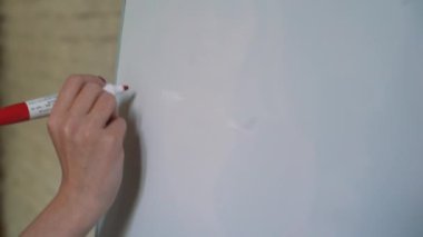 İş adamı, konferans odasındaki sunum sırasında fikirlerini beyaz tahtaya koyuyor. İşaretli kalemle yazı çizelgesine odaklan. Kalem ve beyaz pano ile eli kapat