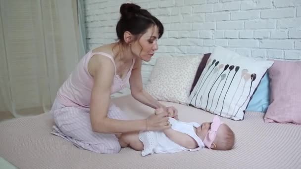 Boldog anya és a baba, csók és ölelés, pihenő ágy együtt, szülési fogalom anyaság szép boldog család — Stock videók
