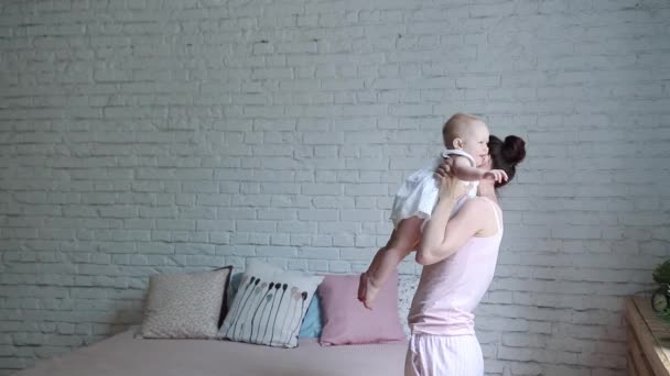 Jeune Mère heureuse tenant son nouveau-né. Famille à la maison. Belle maman souriante et bébé heureux ensemble . — Video