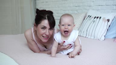 Mutlu anne ve bebek öpüşme ve sarılma, yatak birlikte, annelik kavramı annelik güzel mutlu aile dinlenme