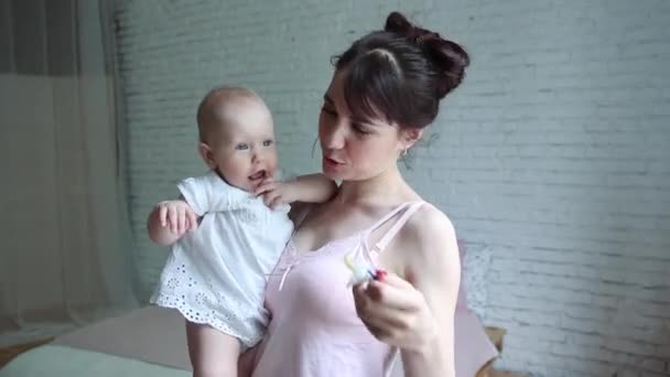 Ребенок с успокаивающим средством, мать держит ребенка за соску — стоковое видео