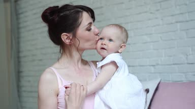 Mutlu anne ve bebek öpüşme ve sarılma, yatak birlikte, annelik kavramı annelik güzel mutlu aile dinlenme