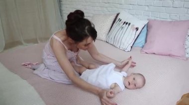 Yeni doğmuş çocuğunu tutan genç mutlu anne. Evde aile. Anne ve mutlu bebek birlikte gülümseyen güzel.