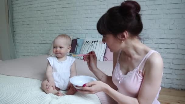 Anne bebek kızı bir kaşıkla besleme. Çok güzel çocuğunu evde anne verilmesi gıda — Stok video