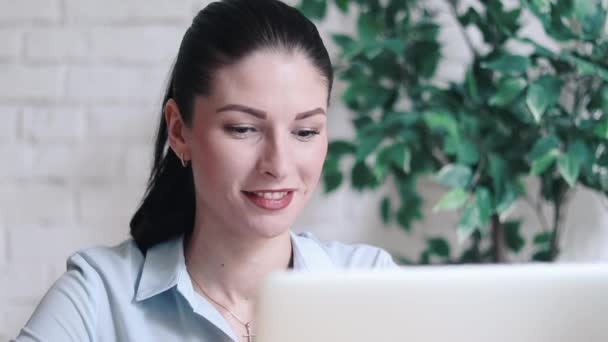 Joven morena mujer de negocios sonriendo detrás de escritorio — Vídeos de Stock