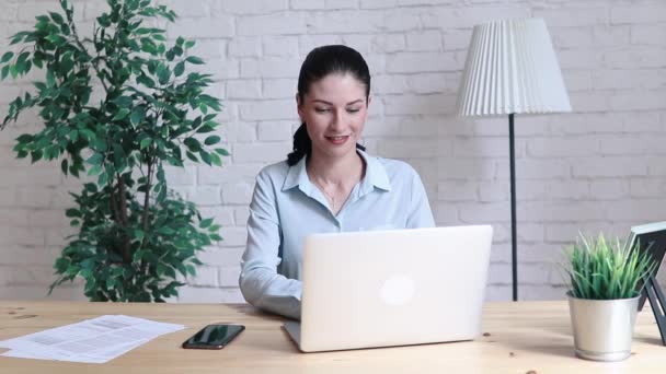 Uso de la mujer portátil y teléfono inteligente en el escritorio en el lugar de oficina — Vídeo de stock