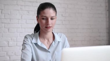 Laptop ile çalışma ve açık alan Bürosu'nda modern iç gelecek hakkında düşünme genç iş kadını