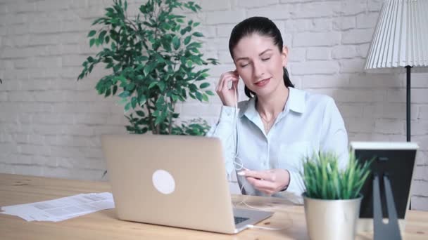 Χαμογελώντας hipster κορίτσι μιλάμε και κουνώντας και Γεια σας κατά τη διάρκεια μιας κλήσης βίντεο με έναν φορητό υπολογιστή που κάθεται στο τραπέζι στο χώρο εργασίας. Χαρούμενα επιχειρήσεων γυναίκα έχοντας μια διάσκεψη στο διαδίκτυο μέσω φορητού υπολογιστή. — Αρχείο Βίντεο