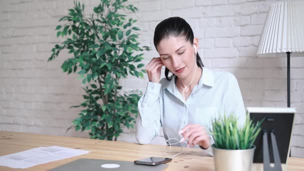 Una mujer en una mesa en la oficina hablando por teléfono . — Vídeos de Stock