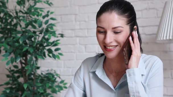 Eine Frau an einem Tisch im Büro telefoniert. — Stockvideo