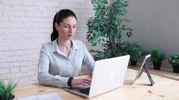 Бізнес жінка має головний біль під час роботи з використанням ноутбука комп'ютера. Напружена і депресивна дівчина торкається її голови, відчуваючи біль, сидячи на дерев'яному столі в кафе. Концепція відмови роботи — стокове відео