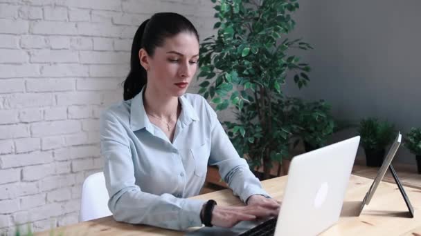 Mujer de negocios que tiene dolor de cabeza mientras trabaja usando computadora portátil. Chica estresada y deprimida tocándose la cabeza, sintiendo dolor mientras se sienta en la mesa de madera en el café. Concepto de fracaso laboral — Vídeos de Stock