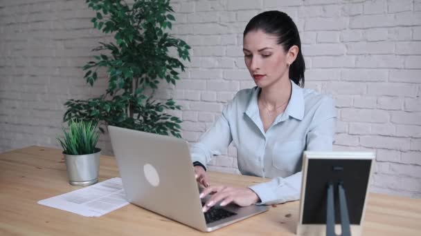 ビジネスの女性は、ラップトップ コンピューターを使用して作業中の頭痛を持っていること。カフェで木製のテーブルに座って痛みを感じ、彼女の頭に触れて強調し、落ち込んでいる女の子。仕事の失敗の概念 — ストック動画