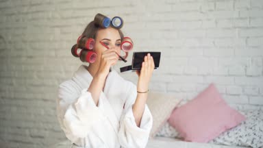 Kadın saç curlers kapalı evde rimel uygulamak