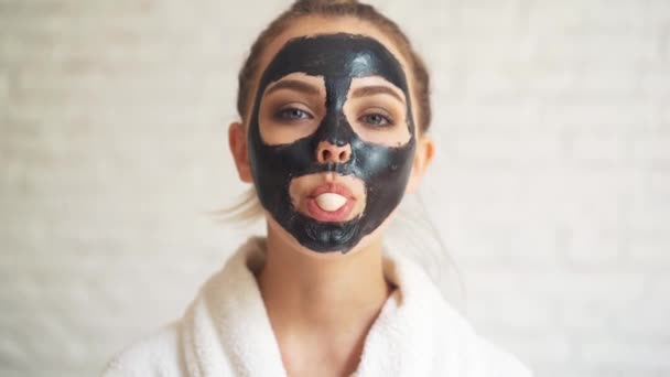 Meisje met een gezichtsmasker, opgeblazen kauwgom. — Stockvideo
