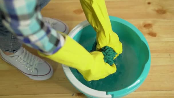 Уборка дома, уборщица сжимает тряпку — стоковое видео