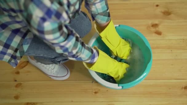Уборка дома, уборщица сжимает тряпку — стоковое видео