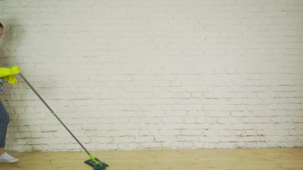 Happy woman in sneakers to wash the floor to the music, dancing — Stock Video