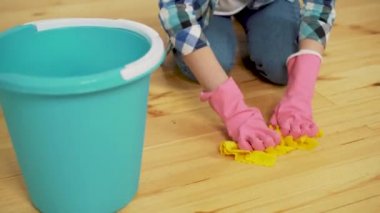 Şok kadın temizlik ile lots-in alet. Genç kız yorgun bir bez bir kova içinde atar..