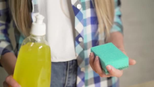 Medios para lavar platos, tareas casuales camisa a cuadros telas concepto de la gente. Primer plano de una señora limpiando los platos usando un detergente viscoso. Chica lavando platos. Una gota de detergente en la esponja — Vídeos de Stock