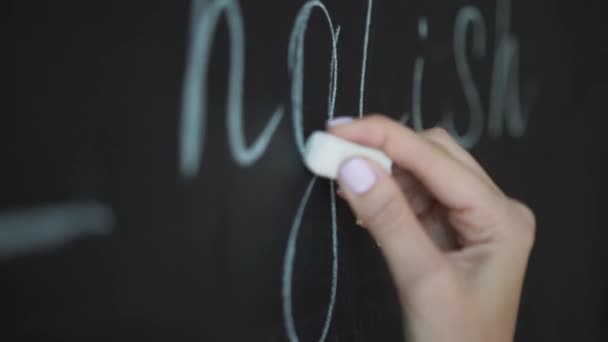 Der Lehrer schreibt mit Kreide Buchstaben des Alphabets auf die Tafel. Bildung im Grundschulkonzept. — Stockvideo