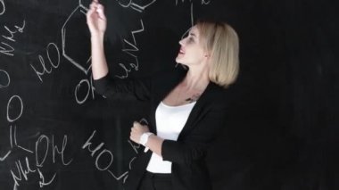 formül kendine güvenen güzel bir kadın öğretmenin tebeşir yazı tahtası arka plan bilim veya kimya öğrenmek