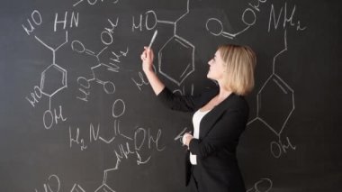 formül kendine güvenen güzel bir kadın öğretmenin tebeşir yazı tahtası arka plan bilim veya kimya öğrenmek