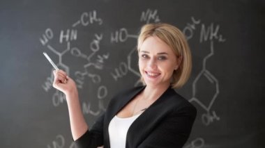 formül kendine güvenen güzel bir kadın öğretmenin tebeşir yazı tahtası arka plan bilim veya kimya öğrenmek
