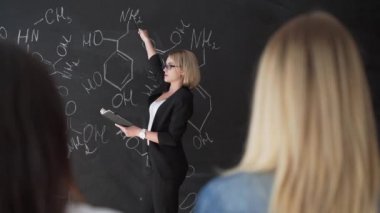 Tebeşir tahtası formülleri yazma öğretmen ve öğrenciler formül açıklar.