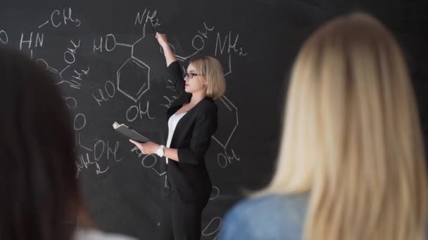 Вчитель написанням формул крейда ради і пояснює студенти формула. — стокове відео