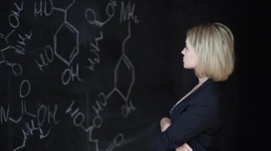 Çözüm hakkında düşünme kimyasal formülü arıyor ve başını, tırmalamak güzel kız öğrenci