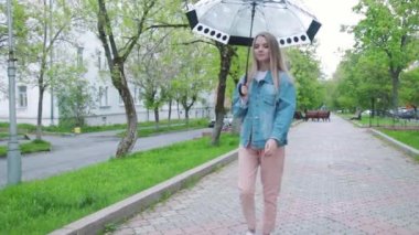 Kız bir şemsiye yağmur altında yürüyüş