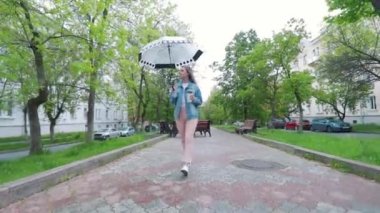 Kız bir şemsiye yağmur altında yürüyüş