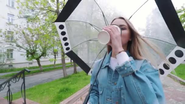 Meisje die onder een paraplu in de regen wandelen — Stockvideo