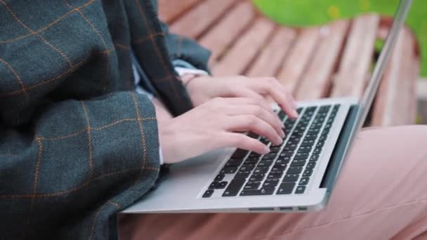 Ung flicka på en bänk med en laptop. Eleven förbereder för examen. — Stockvideo