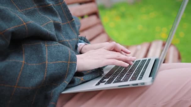 Junges Mädchen auf einer Bank mit Laptop. Student bereitet sich auf Prüfungen vor. — Stockvideo
