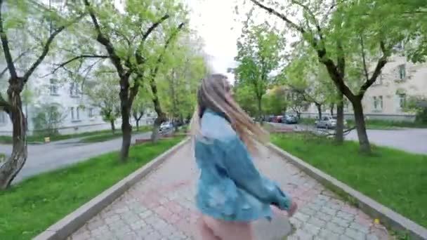 Schöne Teenie-Mädchen hören die Musik zu Fuß entlang der alten Straßen der Stadt und tanzen fröhliche Frau, die Spaß hat — Stockvideo
