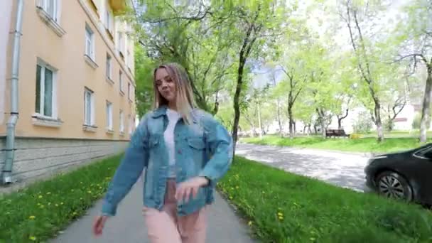 Schöne Teenie-Mädchen hören die Musik zu Fuß entlang der alten Straßen der Stadt und tanzen fröhliche Frau, die Spaß hat — Stockvideo