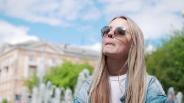 Bir korkuluk havuza bir kot ceket arka plan üzerinde oturan güzel genç kız